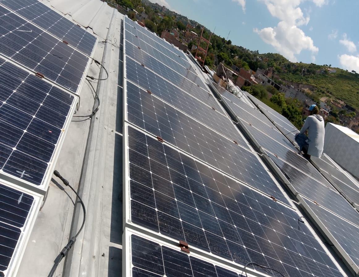 Técnico instalando paneles solares con vista a los cerros de San Miguel de Allende